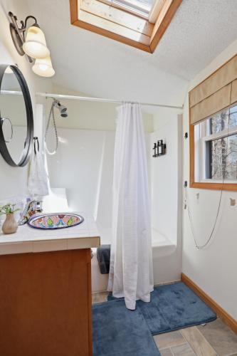 a bathroom with a shower curtain and a sink at Dog-Friendly A-Frame with Hot Tub and Firepit in Hedgesville
