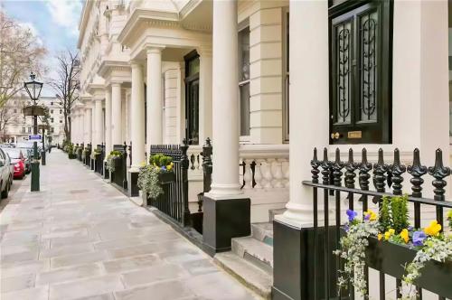 a building with a black fence and flowers on the sidewalk at 250 SqM MEGA MANSION in London