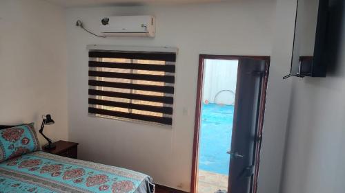 a bedroom with a window and a bed and a door at Piedra Marina Bahia in Bahía de Caráquez
