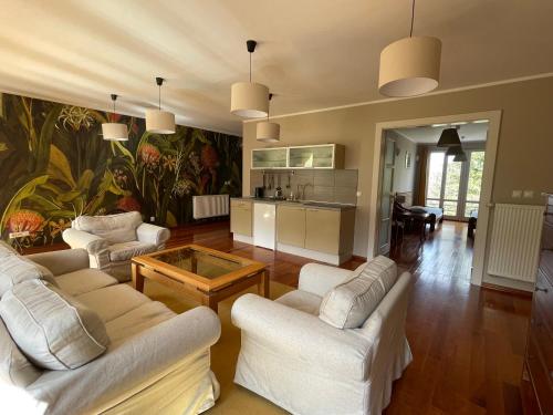 a living room with white furniture and a kitchen at WILLA BOHEMA in Łagów