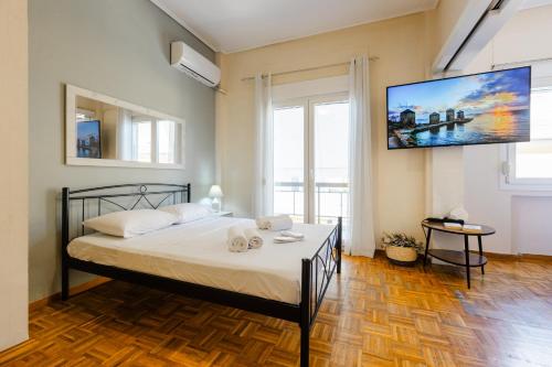 a bedroom with a bed with a tv on the wall at Feel's Like Home Apartment in Chios Town in Chios