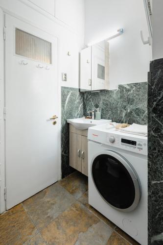 a kitchen with a washing machine and a sink at Feel's Like Home Apartment in Chios Town in Chios