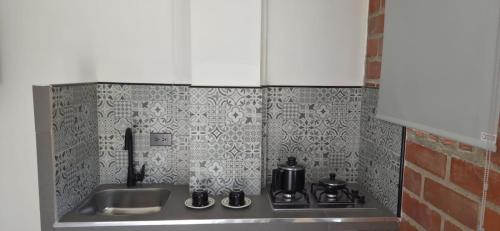 a kitchen counter with a sink and a stove at Don Pedro in Buga