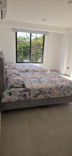 a bed sitting in a room with a window at Don Pedro in Buga