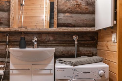 a bathroom with a sink and a washing machine at Pikkukelo Ruka in Ruka