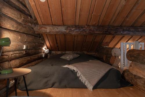 a bedroom with a bed in a log cabin at Pikkukelo Ruka in Ruka