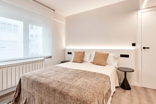 a white bedroom with a bed and a window at AHH ATLANTIC HORIZON HOMES fa in A Coruña