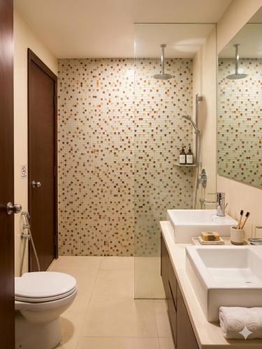 a bathroom with two sinks and a toilet at Ehsan Suites in Kuala Lumpur