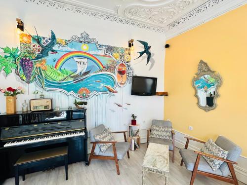 a living room with a piano and a painting on the wall at Porto Wine Hostel in Porto