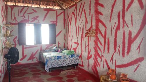a bedroom with red graffiti on the walls at Hostel Mamitchesca in Canoa Quebrada
