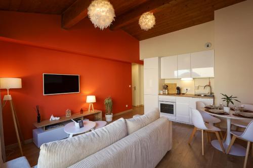 a living room with a white couch and a kitchen at Appartement le cocon de terre in Ambérieu-en-Bugey