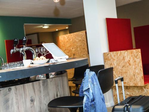 a bar with chairs and a laptop on a counter at ibis Styles Tours Sud in Chambray-lès-Tours