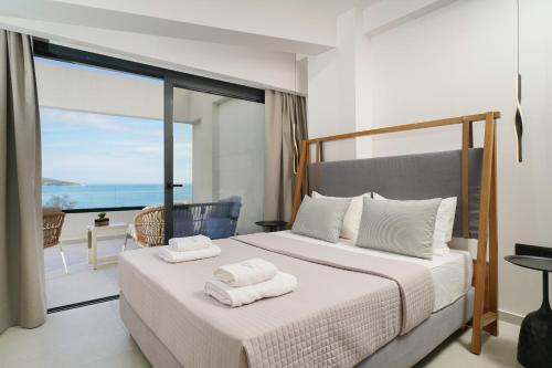 a bedroom with a bed with two towels on it at Videre Golden Private Pool Suites in Potamiá