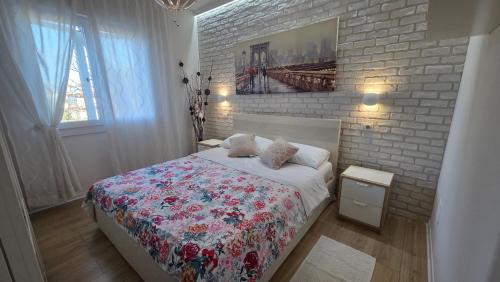 a bedroom with a bed and a brick wall at Loft@Lounge in Grado-Pineta