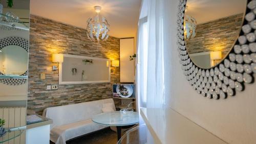 a living room with a table and a mirror at Apartments Barbara in Lovran