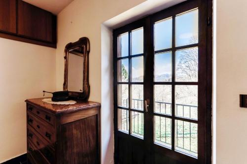 a room with a door and a mirror and a dresser at Chalet Niki BELLAGIO in Bellagio