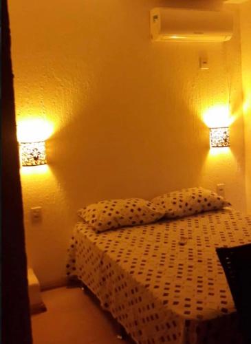 a bedroom with a bed with two lights on it at Quinta Di Crivelli in Praia do Rosa