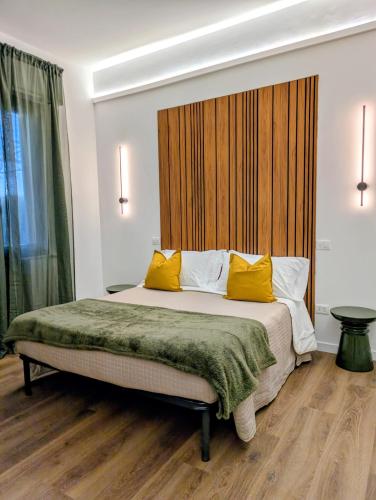 a bedroom with a bed with two yellow pillows at Chianciano Lettings -Room and Apartments- in Chianciano Terme