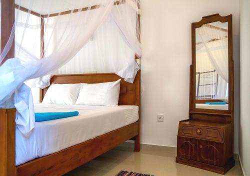 a bedroom with a bed and a mirror at Eden Blue Hikkaduwa in Hikkaduwa
