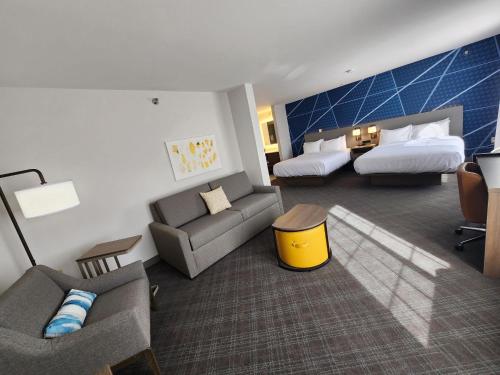a hotel room with a couch and a bed at Comfort Inn & Suites Summerset - North Rapid City in Summerset