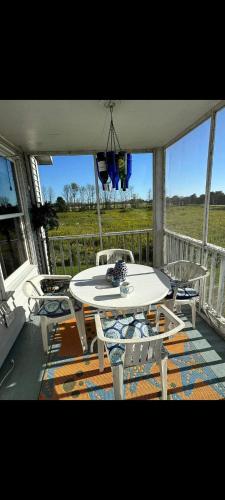 a patio with a table and chairs on a porch at Beach House Overlooking Lake Michigan in Algoma
