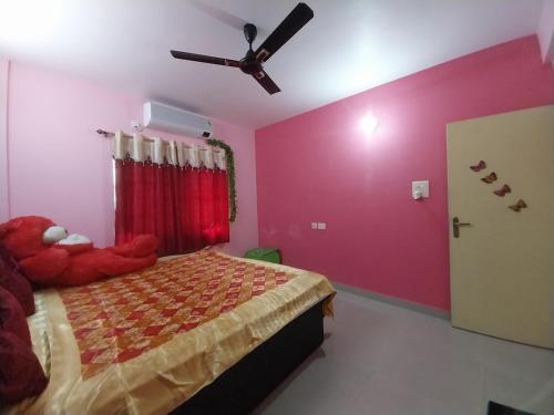 a bedroom with a bed and a ceiling fan at Starlight Guest House in kolkata