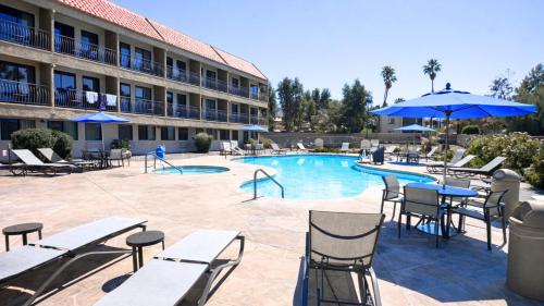 a pool with tables and chairs and a hotel at Holiday Inn Express Palm Desert by IHG in Palm Desert