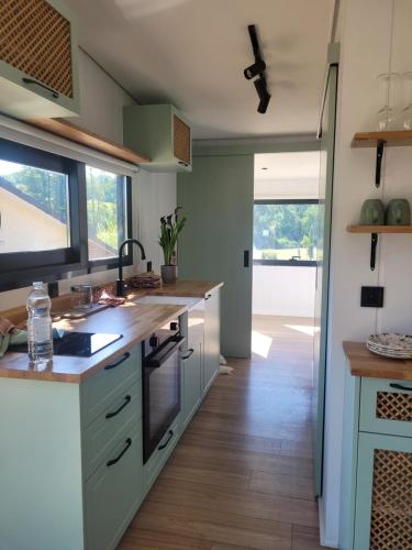 a kitchen with green cabinets and a large window at Au Coin du Chêne in Thaon-les-Vosges