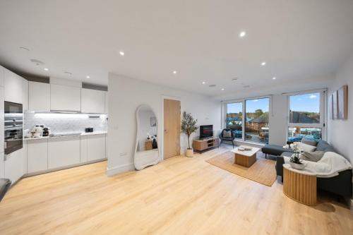 a living room with a couch and a table at Modern & Cozy 2-Bedroom Apartment plus Parking, Gym, Cinema, Games Room, Workspace in New Malden