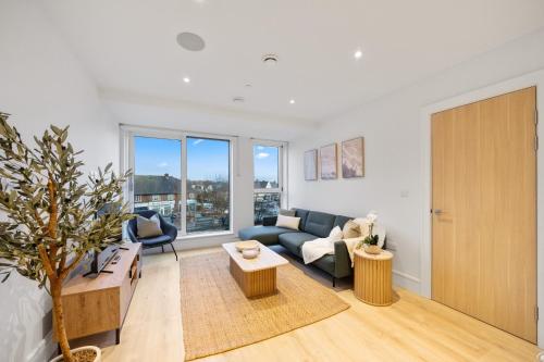 a living room with a couch and a table at Modern & Cozy 2-Bedroom Apartment plus Parking, Gym, Cinema, Games Room, Workspace in New Malden