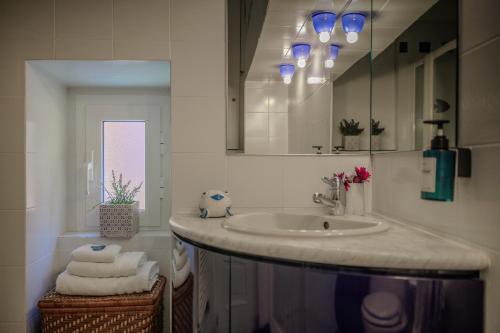 a bathroom with a sink and a mirror and towels at Bilocale affacciato sul budello a 30 mt dal mare in Laigueglia