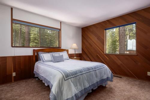 a bedroom with a bed and two windows at Villa Bossi in Carnelian Bay