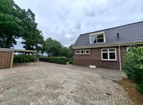 an empty driveway in front of a brick house at Wedderhoeske in Wedde