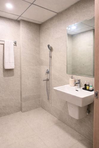 a bathroom with a sink and a shower with a mirror at StayScape studio in Greater Noida