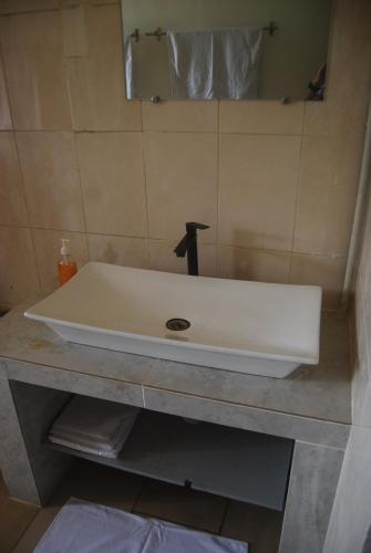 a white sink on a counter in a bathroom at Laguna Lodge in Ouidah
