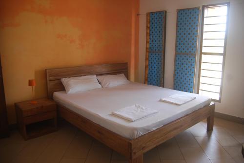a bedroom with a bed with two towels on it at Laguna Lodge in Ouidah