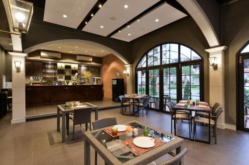Un restaurante con mesas y sillas y un bar. en Le Monte Khao Yai, en Mu Si
