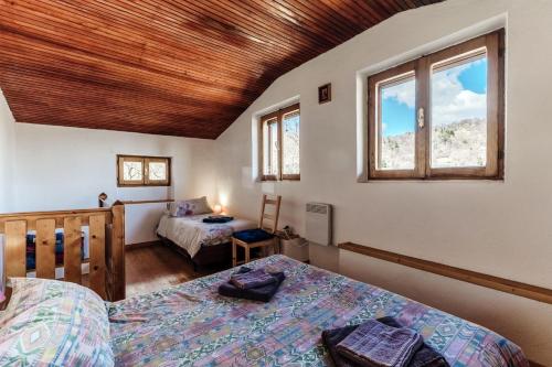 a bedroom with two beds and two windows at Chalet Tessa BELLAGIO in Bellagio