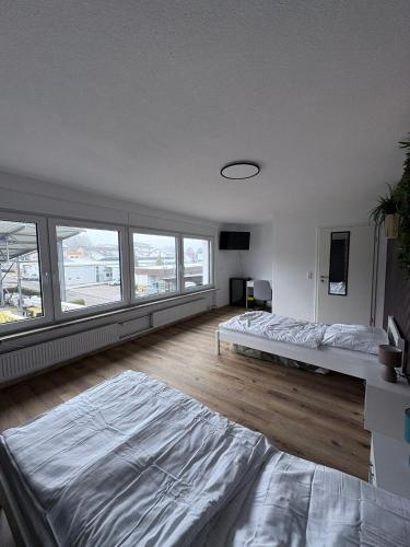 a bedroom with two beds and a large window at Gästehaus GAP in Dietlingen