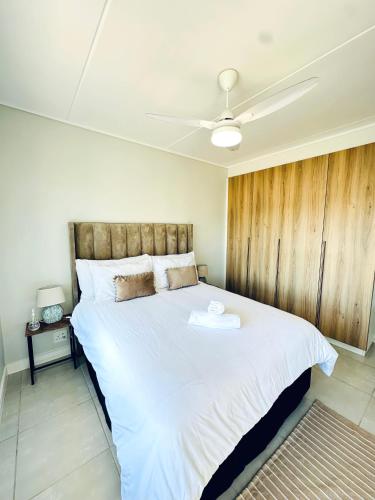 a bedroom with a large bed with a wooden wall at Spacious 3 Bedroom Apartment in Ballito Hills Lifestyle Estate Near Ballito Beach in Ballito