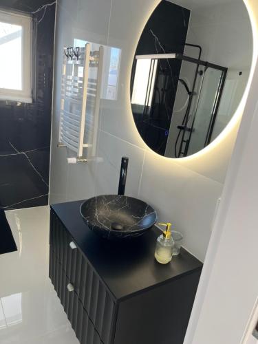 a bathroom with a black sink and a mirror at DOM LAGOWSKI z SAUNA in Łagów