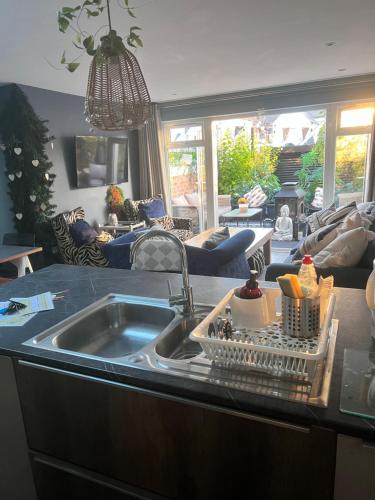 a kitchen with a sink and a living room at Sandy feet retreat in Exmouth