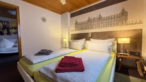 a bedroom with two beds and a painting on the wall at City B&B Cochem in Cochem