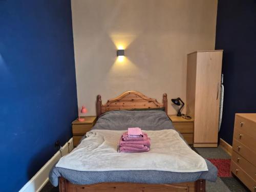 a bedroom with a bed with a pink towel on it at The Tartan Sheep in Kilmarnock