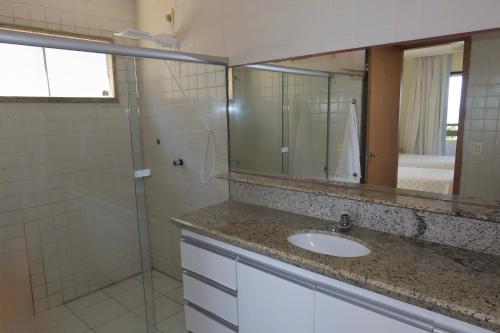 a bathroom with a sink and a mirror at Porto Brasil Resort - Casa de praia em condomínio de luxo in Parnamirim
