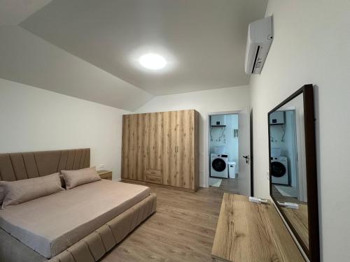 a bedroom with a bed and a mirror and a table at Olivea Suites Tirana in Tirana