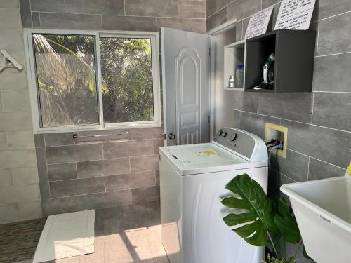 a bathroom with a washing machine and a window at Apartamento Carey in Cabrera