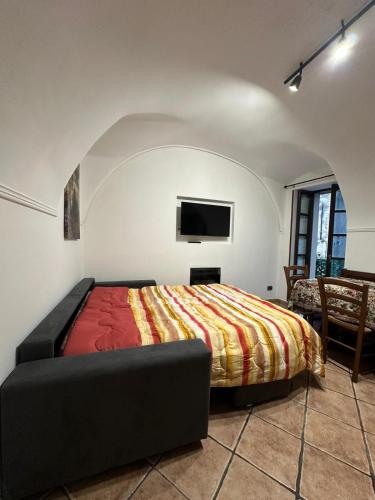 a bedroom with a bed and a flat screen tv at Il Dolce Rustico in Dolceacqua