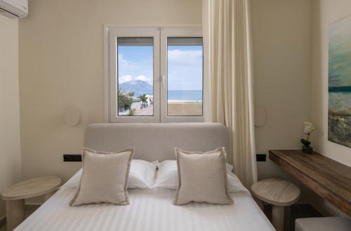 a bedroom with a bed with a view of the ocean at Phos Luxury Living in Sarti