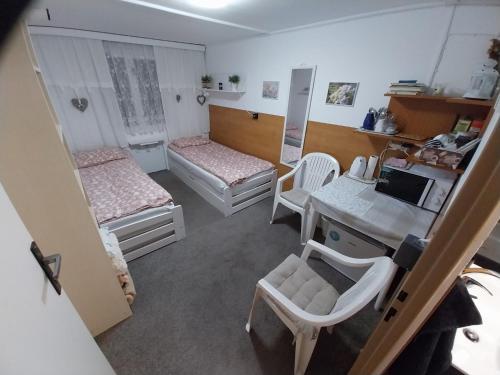 a room with two beds and a table and a desk at Chatka pod Javorovým in Třinec